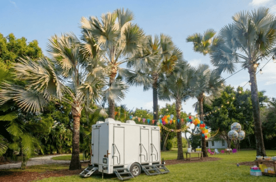 Luxury portable restroom trailer at outdoor birthday party venue with palm trees and balloons in Florida – YML